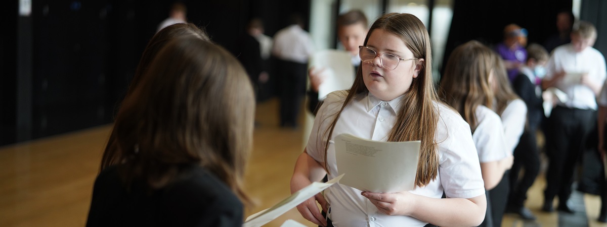 Two girls holding a script perform at a drama workshop