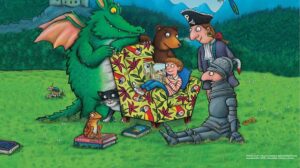 A dragon, cat, bear, pirate and knight stand around a boy sat in a chair reading a book in the promotional image for Charlie Cook's Favourite Book