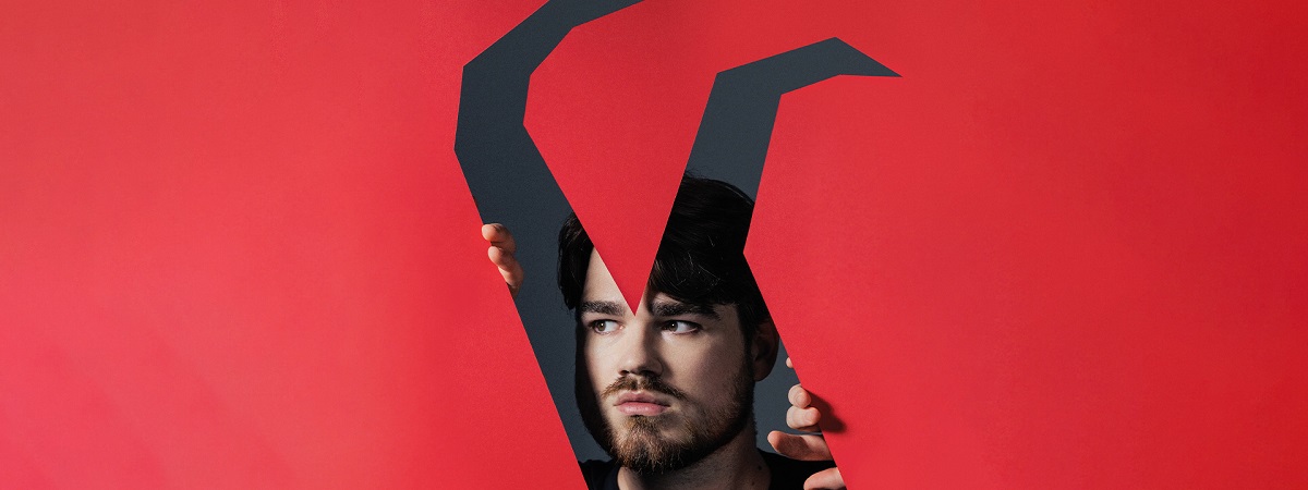 A man looks on through cut out horns in a promotional image for English Touring Opera's The Rake's Progress.