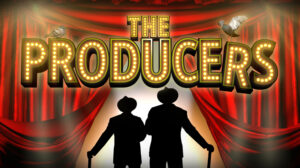 The Producers. An image of two silhouettes stood in front stage curtains opening.