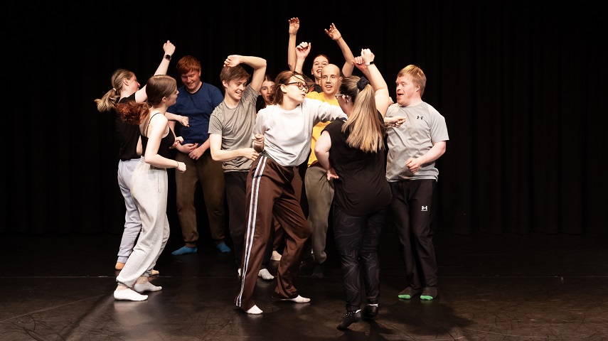 A group of young people dance in a promotional image for Tin Arts' SLIDE