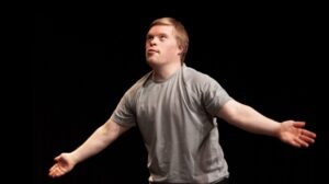 A person holds their arms outstretched in a promotional image for Tin Arts' Best Foot Forward.