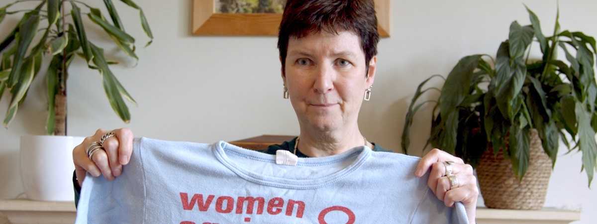 Kate holding up a T-shirt in Iron Ladies