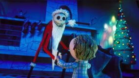 Jack Skellington dressed as Santa presents a child with a present in a still from The Nightmare Before Christmas.