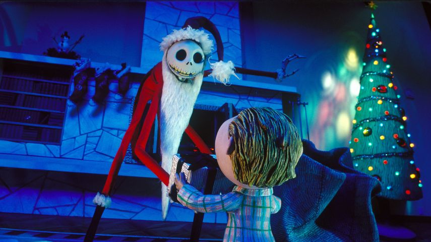 Jack Skellington dressed as Santa presents a child with a present in a still from The Nightmare Before Christmas.